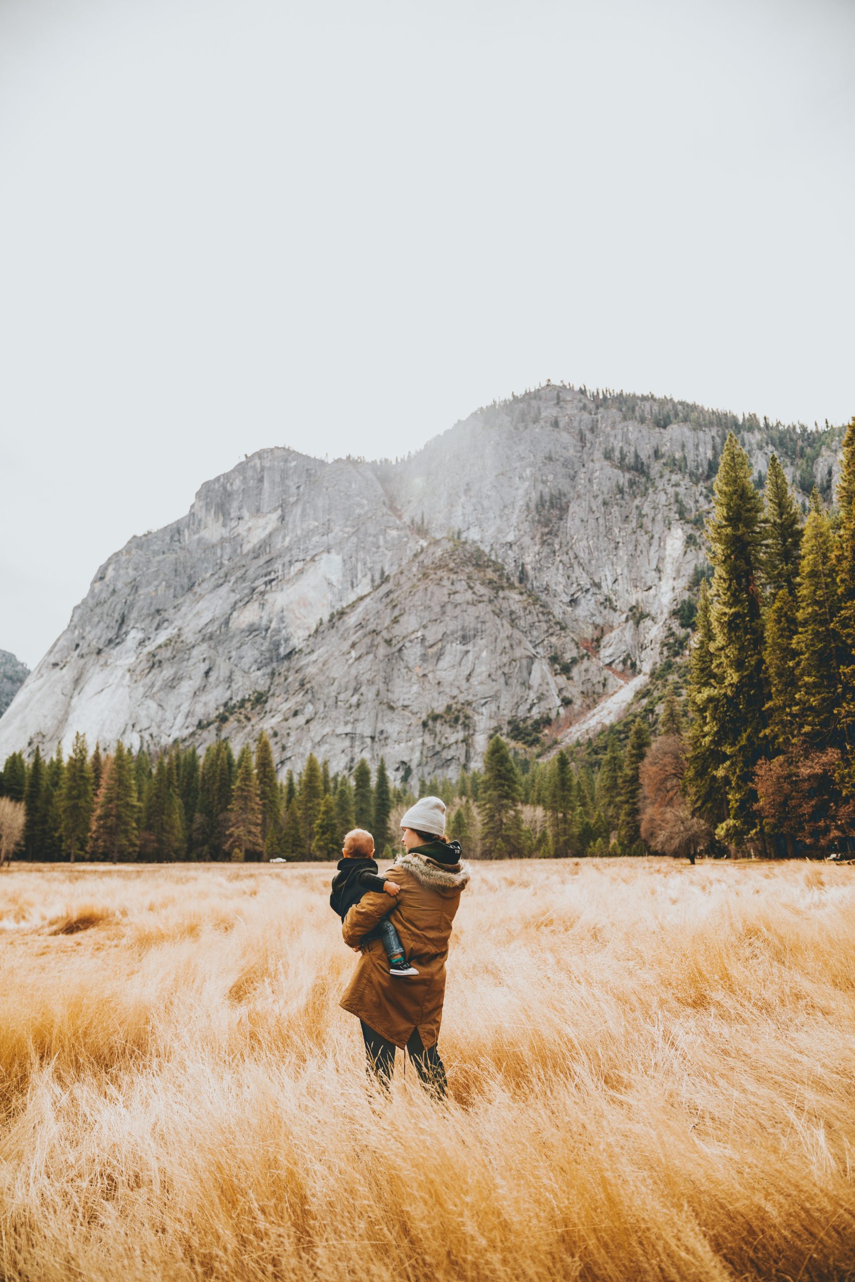 Photo par Nathan Dumlao person standing on grass field while carrying child